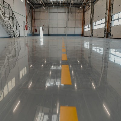 Warehouse floor in grey gloss with a row of yellow line markings