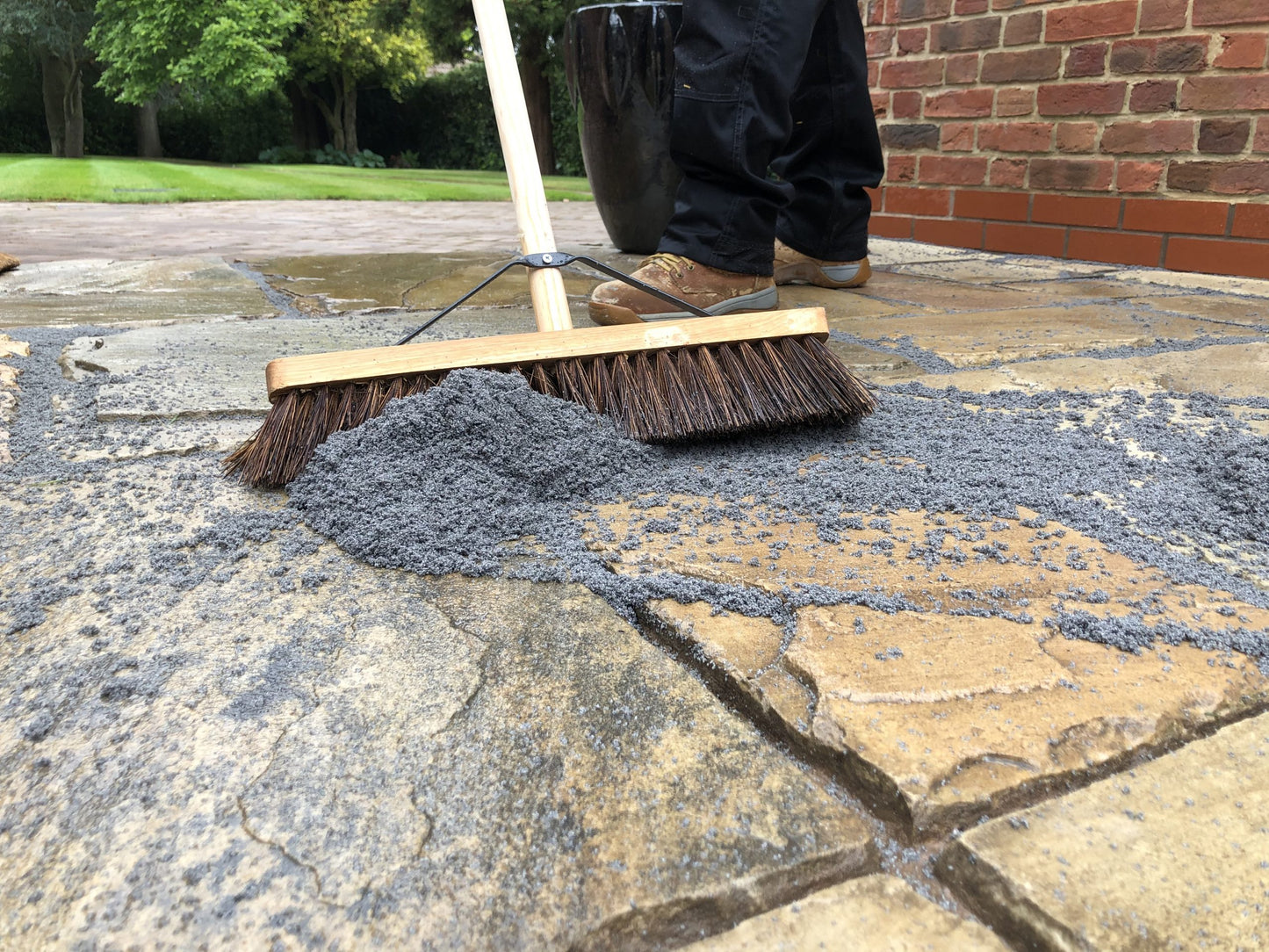 Brushing Premjoint jointing compound between paving slabs