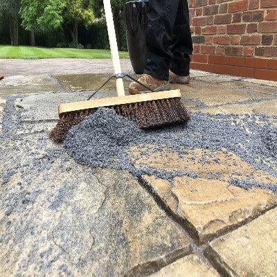 Brushing Premjoint jointing compound between paving slabs