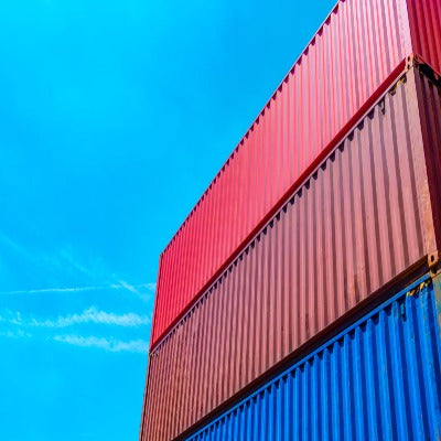Shipping Containers painted red and blue, with bright blue sky behind